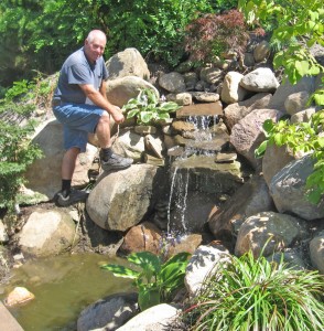 Ran Lydell inspecting the new water feature at Eagle Bay Gardens.