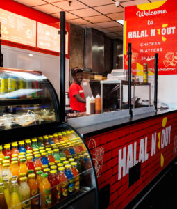 A staff member stands behind the takeout counter at Halal-N-Out restaurant in Rochester NY