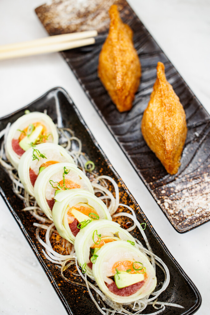 Two rectangular plates with a Naruto roll and inari nigiri at Umai Revolving Sushi in Rochester NY