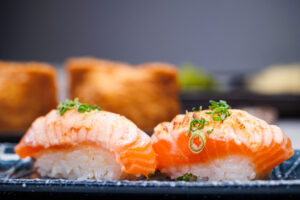 Close-up of two pieces of seared salmon sushi at Umai Revolving Sushi conveyor belt Japanese restaurant in Rochester NY