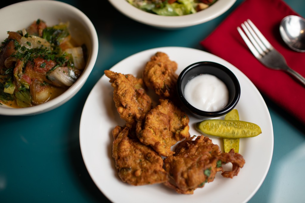 A plate of bhajia, crispy roasted broccoli fritters battered in spiced chickpea flour, at Natural Oasis Market vegan vegetarian restaurant in Rochester NY