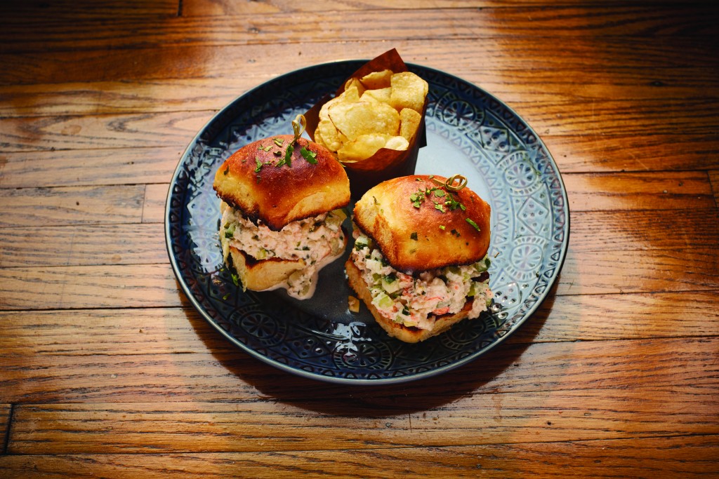 A plate with two Rock Shrimp Sliders and chips at Rella oyster bar in Rochester NY