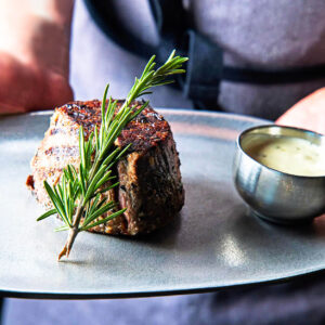 A filet steak garnished with a twig of rosemary at Black and Blue Steak and Crab Restaurant in Rochester NY