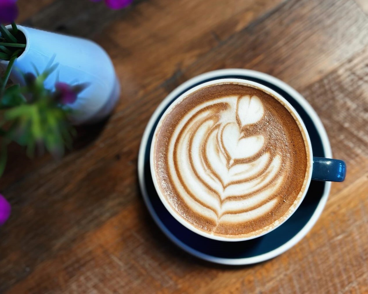 An artfully finished mocha on a wooden table at FairPour Coffee Roasters in Fairport NY