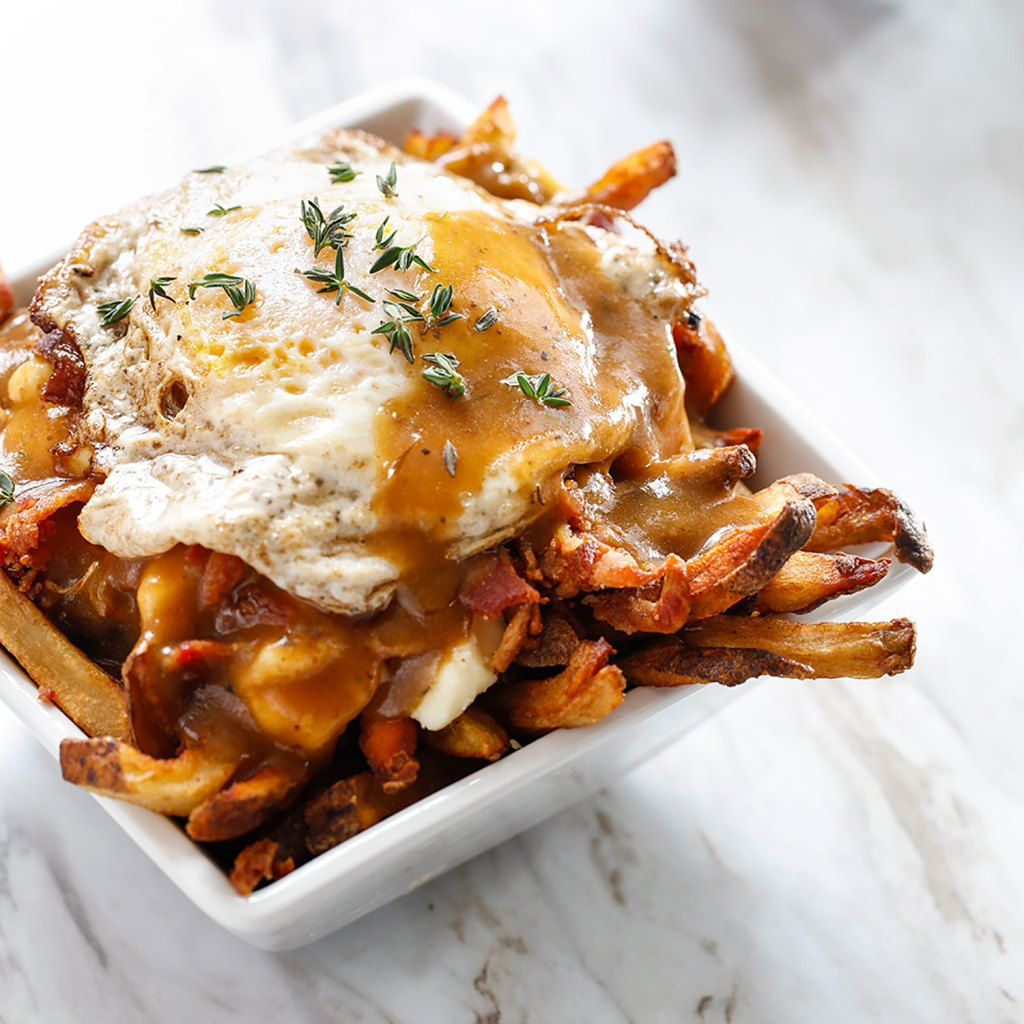 Breakfast poutine with beef gravy, bacon, egg over easy and thyme from Le Petit Poutinerie food truck in Rochester NY