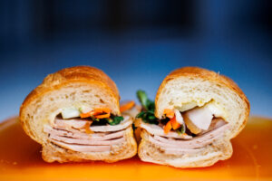 Close-up view showing the filling of the house banh mi with pork belly at Sea Me Go restaurant in Rochester NY