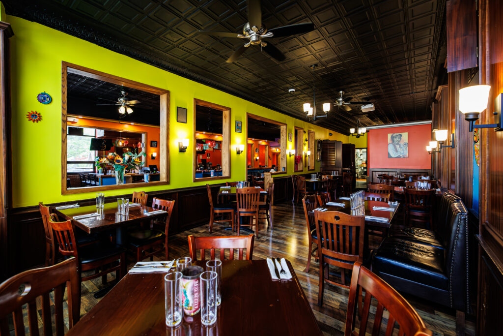 The inviting interior with wooden tables, benches and coffered ceiling at Tavo’s Antojitos y Tequila in Rochester NY