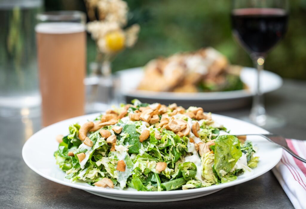 The saladboy: Bolton Farms kale and brussels sprouts, lemon vinaigrette, horseradish aioli, and cashews at The Owl House vegan restaurant in Rochester NY