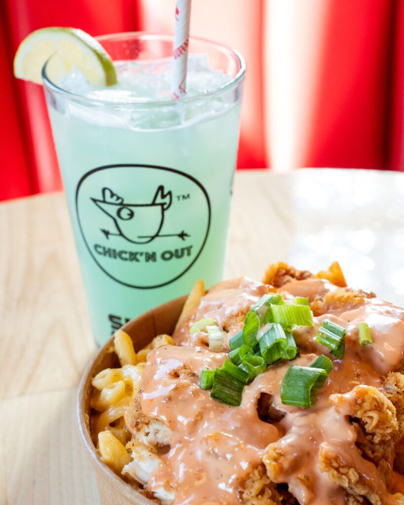 A Blue Lagoon cocktail and the Mac Attack: mac and cheese, garlic parmesan fries, fried chicken topped with Mac Daddy sauce at Chick'n Out restaurant in Rochester NY