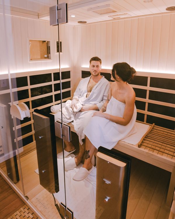 Man and woman sitting in infrared sauna at Sarah Rizzo Skin and Boutique in Rochester, N.Y.