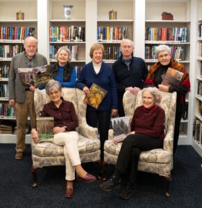 Seven residents of The Highlands at Pittsford senior living in front of bookcases in Rochester, N.Y.