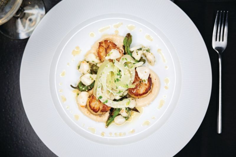 Sea scallops with roasted cauliflower cream, blue crab, fennel, shishito, lemongrass, scallion, and crisp rice at Patron Saint in Rochester, N.Y.