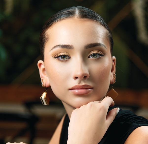 Close up of model Quinn Gagnier's wearing book earrings with hand on top of a book taken in Rochester, N.Y.