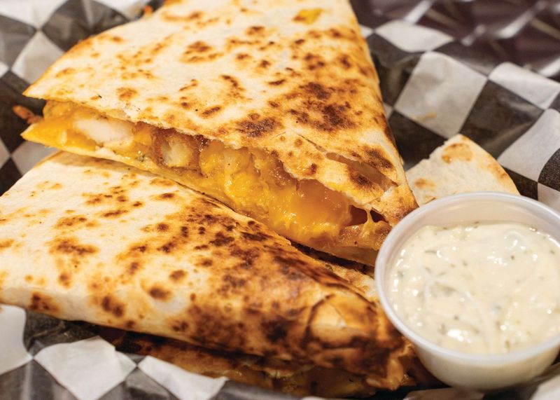 The Dillified quesadilla with crispy chicken, fried pickle chips, and melted cheddar jack with a side of garlic blue sauce at The Grilled Cheese Factory ROC in Rochester, N.Y.