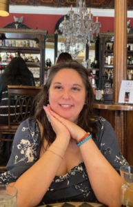 Christine Green, managing editor for 585 magazine, posing with hands under face in a cafe.