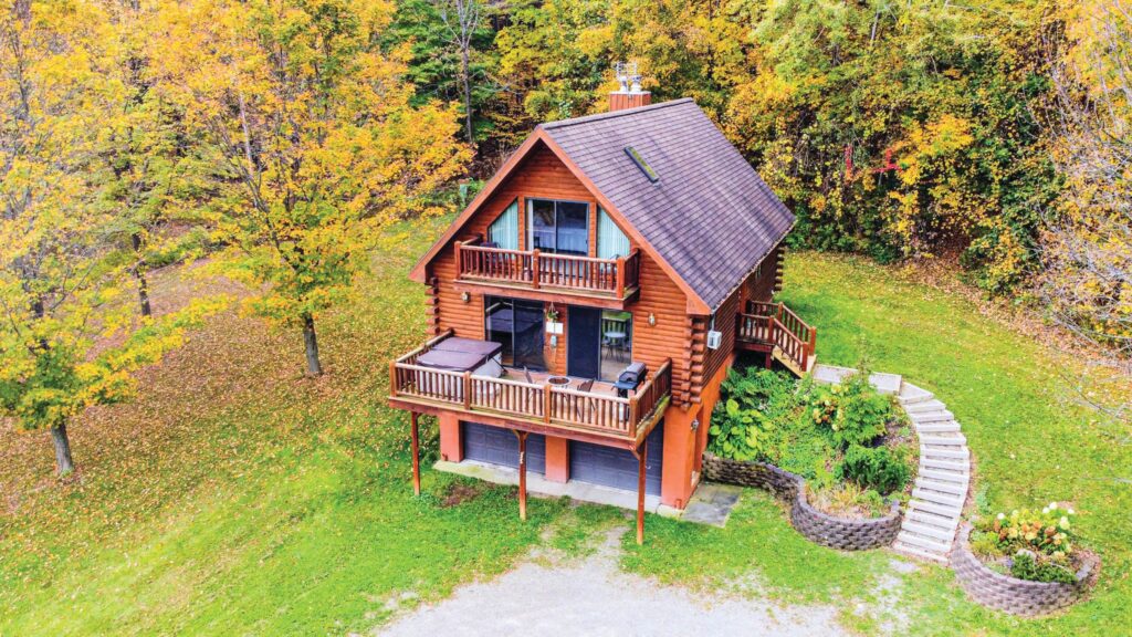 A 3-story vacation cabin surrounded by trees as part of The Quiet Place Getaways located in the Finger Lakes region.