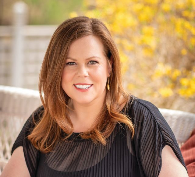 Erin Crowley, comanaging partner of the Crowley Center for Regenerative Biotherapeutics, posing on outdoor couch in Rochester, N.Y.