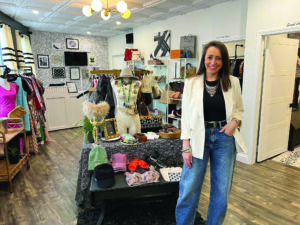Sarah Pavia, owner of Second Look Boutique, posing in the middle of her store in Rochester, N.Y.